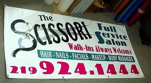 Pink and white salon vinyl banner with a large phone number