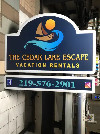 Cut-to-shape blue vacation rental sign with a lake and sun design